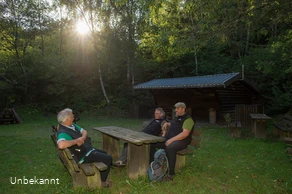 Schutzhütte und Bänke mit Wanderern